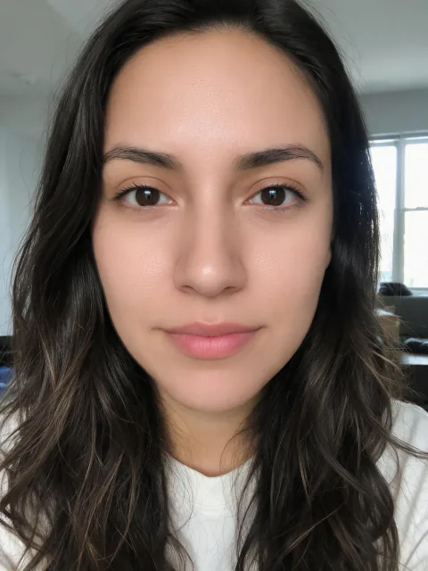 The woman's same selfie with Beautify Me at Pronounced: skin and under-eyes retouched; hair, clothes and background unchanged